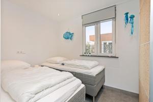 Dos camas en una habitación con ventana. en Vakantiehuis Zee, Bos & Duin Zoutelande ZO01, en Zoutelande