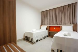 um quarto de hotel com duas camas e uma janela em APARTAMENTO RESORT EM OLÍMPIA em Olímpia
