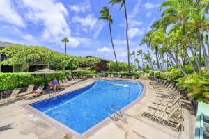a pool at a resort with chairs and palm trees at Napili Shores G157 condo in Kahana