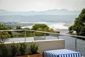 a balcony with a table and a view of a beach at Plett Holiday Apartment in Plettenberg Bay