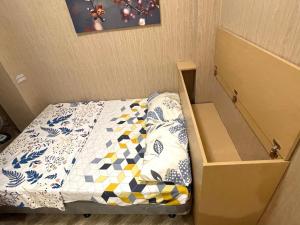 a small bed in a room with a box at JT RESIDENCES QC SANITIZE GAMES FIBER INTERNET NETFLIX THOUSAND CABLE TV in Manila