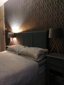 a bedroom with a bed with a headboard and a lamp at Wavecrest in Holyhead