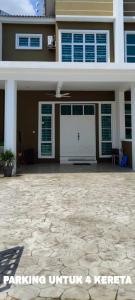 a house with a white garage and a driveway at OneFamily Homestay in Kuala Terengganu