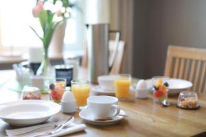 a wooden table with plates and glasses of orange juice at Park Hotell in Kristinehamn