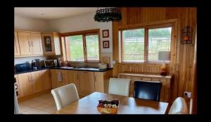 a kitchen with wooden cabinets and a table and chairs at Drumcoura Dreamescape in Ballinamore