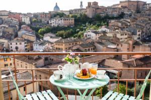 una mesa con un plato de comida y café en el balcón en Hotel Minerva, en Siena