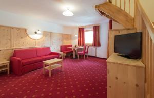 ノーヴァ・レヴァンテにあるAktiv Hotel Schönwaldのリビングルーム(赤いソファ、薄型テレビ付)