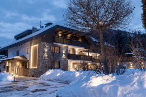 a house in the snow at night at Aparthotel Familiaris - Family Apartments - Pools & Spa in Dolomites in Valdaora