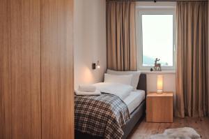 ein Hotelzimmer mit einem Bett und einem Fenster in der Unterkunft die Tauplitz Lodges - Wasserfall Lodge C4 by AA Holiday Homes in Tauplitz