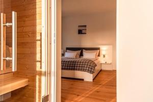 een slaapkamer met een bed en een houten vloer bij die Tauplitz Lodges - Bergblick Lodge B6 by AA Holiday Homes in Tauplitz