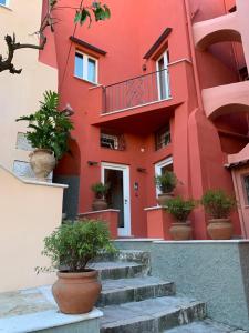 a red building with stairs and potted plants at Dimora del Leone Gaeta in Gaeta
