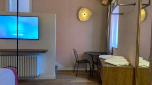 a room with a table and a tv on the wall at Dimora del Leone Gaeta in Gaeta