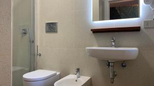 a bathroom with a sink and a toilet and a mirror at Dimora del Leone Gaeta in Gaeta