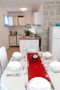 einen weißen Tisch mit einem roten Tischtuch drauf in der Unterkunft Apartment Meri in Trogir