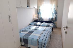 a small bedroom with a bed and a window at Apartment Meri in Trogir