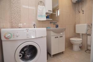 ein kleines Bad mit einer Waschmaschine und einem Waschbecken in der Unterkunft Apartment Meri in Trogir