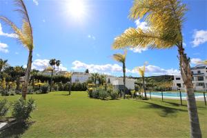 a park with palm trees and a swimming pool at Apartment AMARA in Estepona