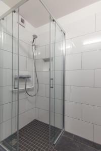 a shower in a bathroom with white tiled walls at DJH Jugendherberge Torgau in Torgau