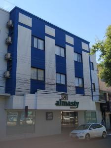 a blue building with a car parked in front of it at Almasty Hotel in Chapecó