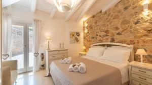 a bedroom with a bed with two towels at Tenuta Scialandre 10, Emma Villas in Patù