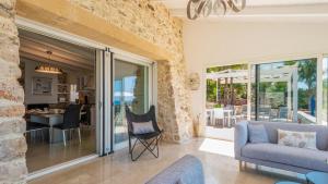 a living room with glass doors and a stone wall at Tenuta Scialandre 10, Emma Villas in Patù