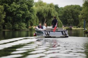 a man and a woman on a boat in the water at The Runnymede on Thames in Egham