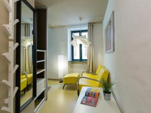 a living room with yellow chairs and a table at Tre Porte Rovinj in Rovinj
