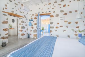 a bedroom with a large bed in a room with rocks on the wall at Veranta Luxury Suite in Khóra Sfakíon