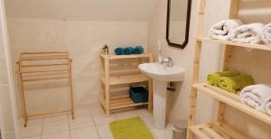 a bathroom with a sink and a toilet and towels at Chez Mélo in Loctudy