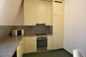 a kitchen with white cabinets and a microwave at Cosy 2-bedroom near lake - Stardust 31 in Zurich
