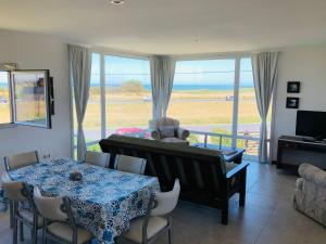 a living room with a table and a view of the ocean at Casa del Mar in Mar del Plata