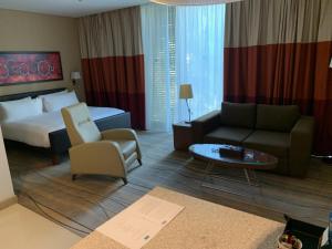 una camera d'albergo con letto, divano e tavolo di Staybridge Suites Beirut, an IHG Hotel a Beirut