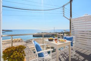 uma mesa e cadeiras numa varanda com vista para o oceano em FantaSea Luxury Suite em Chora Sfakion