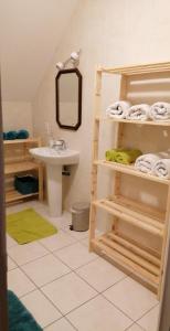 a bathroom with a sink and a mirror and towels at Chez Mélo in Loctudy