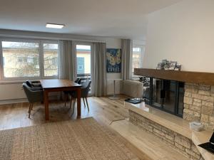 ein Wohnzimmer mit einem Tisch und einem Kamin in der Unterkunft Ferienwohnung Parsennblick mit Dachterrasse in Davos