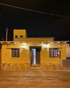 a yellow house with lights on it at night at Hosteria Las Tinajas in Tilcara