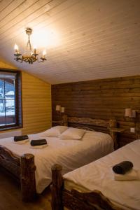 ヴァトラ・ドルネイにあるCHALET RELAXのベッド2台とシャンデリアのある寝室