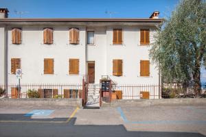 a white building with brown shutters on it at Casa Cà Romana in Brenzone sul Garda +17 photos