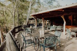 a patio with tables and chairs on a deck at Letaba River Lodge in Tzaneen