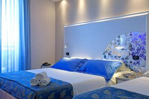sypialnia z dwoma łóżkami i ręcznikami na górze w obiekcie Hotel Krone w mieście Lido di Classe