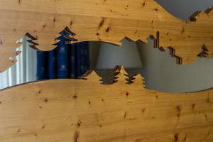 eine Holzwand mit einer Schnitzerei eines Waldes darauf in der Unterkunft Hotel Rivè - Complesso Turistico Campo Smith in Bardonecchia