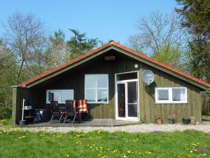 a small house with a deck and chairs in it at Ferienhaeuser Abild - Urlaub auf dem Bauernhof in Tarp