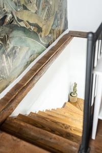 a wooden stair case with a painting on the wall at La Carmona House in Lodero