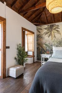 Lodero的住宿－La Carmona House，卧室配有一张床,墙上挂有绘画作品