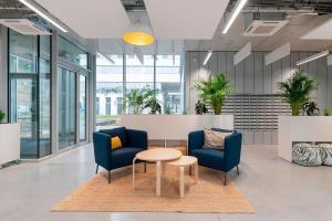 - un hall avec deux chaises bleues et une table dans l'établissement Student Factory Lille Euratechnologies, à Lille