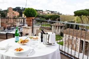 einen Tisch mit Speisen und Weinen auf dem Balkon in der Unterkunft 47 Boutique Hotel in Rom