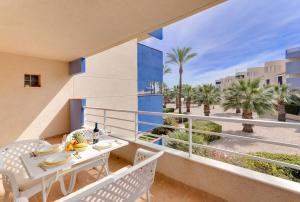 a balcony with a table and chairs and palm trees at Apartament PALMERA 100m od morza in Orihuela