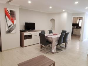 a dining room with a table and chairs and a television at Forte Beach- Albufeira in Albufeira