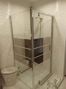 y baño con ducha y puerta de cristal. en Apartament w Krzesznej, en Krzeszna