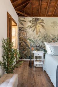 a bedroom with a mural of palm trees on the wall at La Carmona House in Lodero